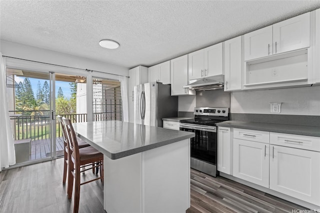 98-685 Kaonohi St Unit E, Aiea, HI 96701 - kitchen with appliances with stainless steel finishes, under cabinet range hood, dark countertops, a center island, and white cabinetry