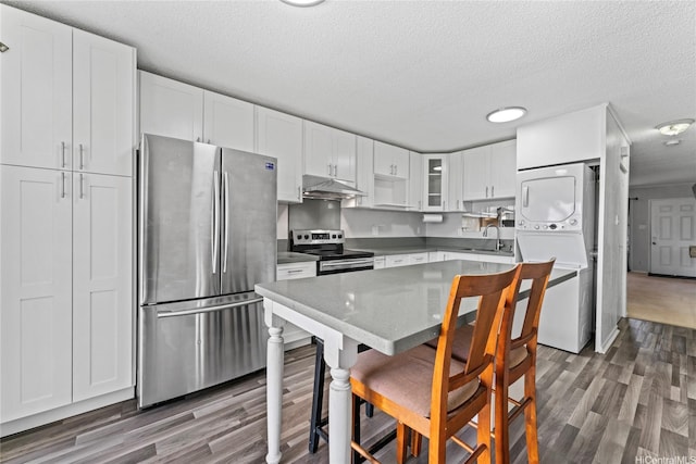 98-685 Kaonohi St Unit E, Aiea, HI 96701 - kitchen featuring appliances with stainless steel finishes, stacked washer / dryer, under cabinet range hood, a sink, and wood finished floors