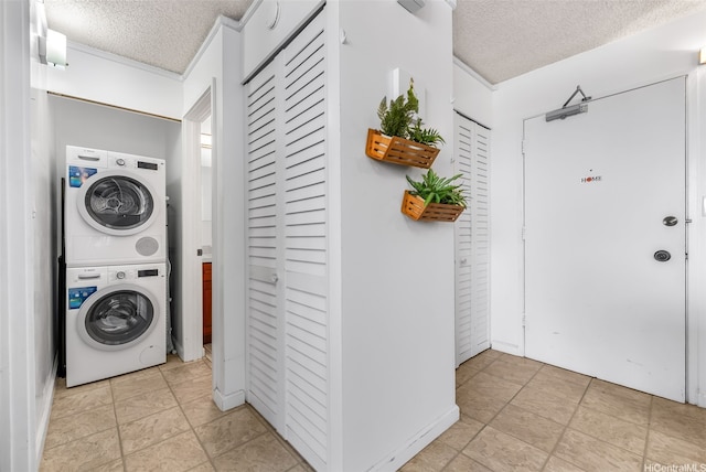 laundry area with stacked washer and clothes dryer, a textured ceiling, and laundry area
