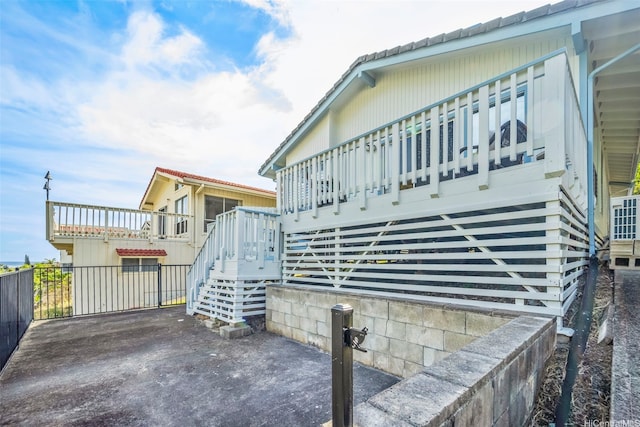 view of side of property featuring a wooden deck, a patio area, and stairs