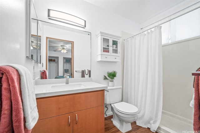full bathroom featuring wood finished floors, vanity, curtained shower, ceiling fan, and toilet