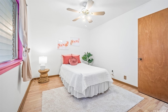 bedroom with baseboards, a ceiling fan, and light wood-type flooring