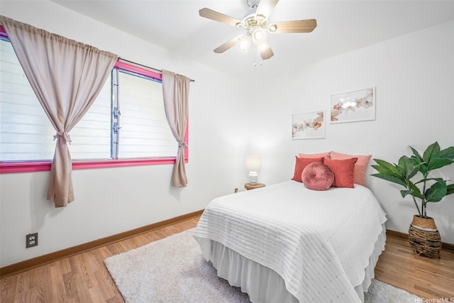 bedroom with wood finished floors, a ceiling fan, and baseboards