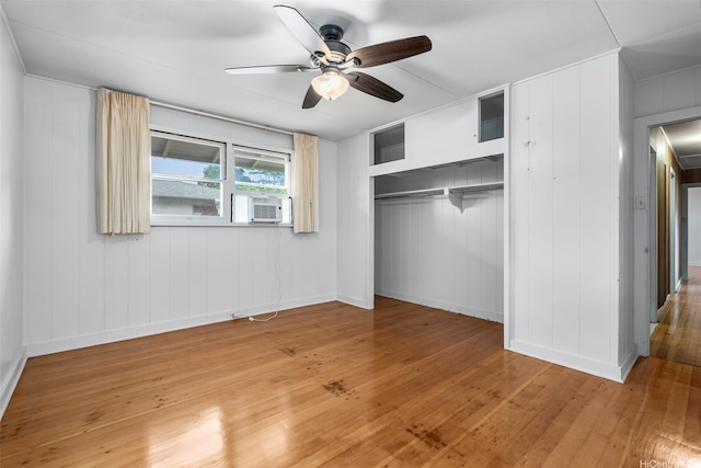 unfurnished bedroom with cooling unit, light wood finished floors, a closet, and baseboards