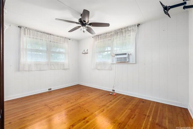empty room featuring a ceiling fan, baseboards, and light wood-style floors