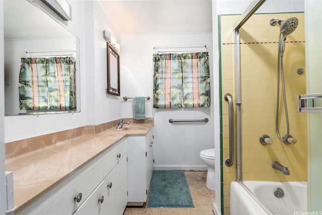 bathroom featuring toilet, tile patterned flooring, enclosed tub / shower combo, and vanity
