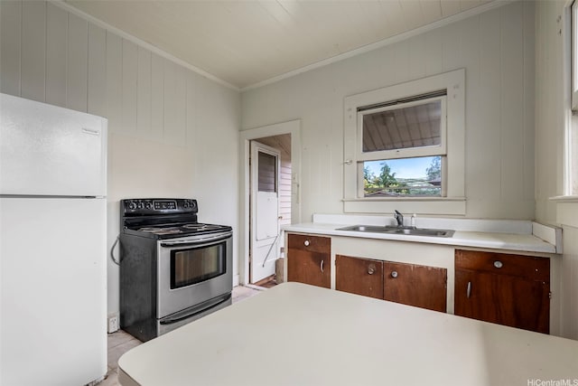 kitchen featuring ornamental molding, electric stove, freestanding refrigerator, and light countertops