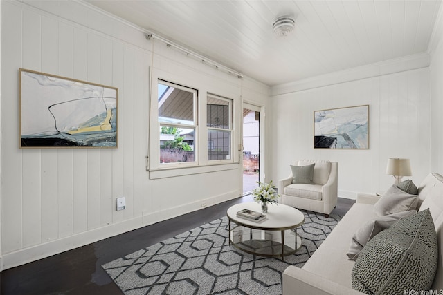 living room featuring dark wood-style floors, baseboards, and ornamental molding