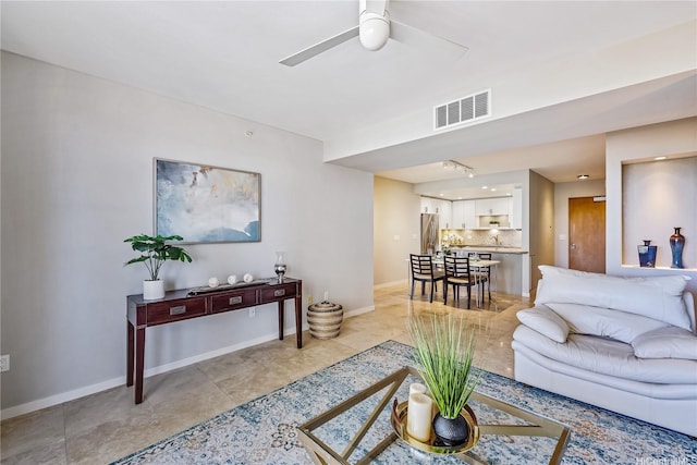 living room with a ceiling fan, baseboards, and visible vents