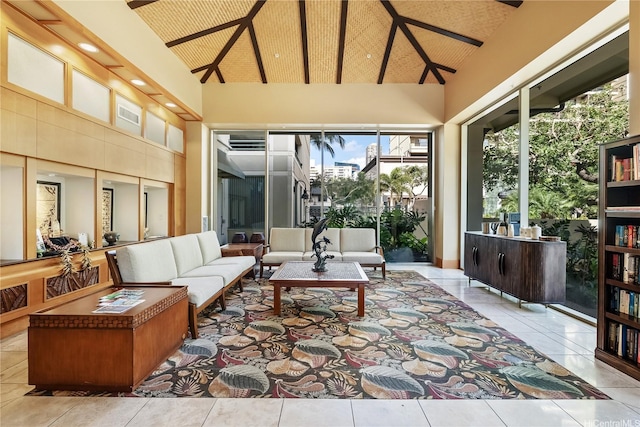 living room with plenty of natural light, beam ceiling, tile patterned floors, and high vaulted ceiling