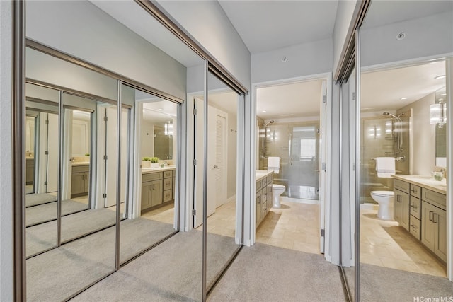 interior space with a walk in shower, toilet, tile patterned flooring, and vanity