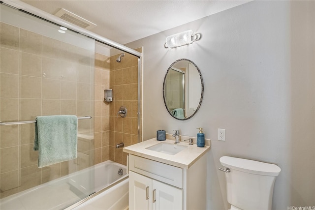 bathroom featuring toilet, visible vents, bath / shower combo with glass door, and vanity