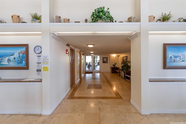 corridor with baseboards and light tile patterned floors