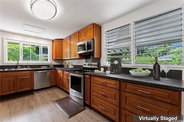 45-533 Pahia Rd, Kaneohe, HI 96744 - kitchen with brown cabinetry, light wood-style floors, a sink, backsplash, and stainless steel appliances