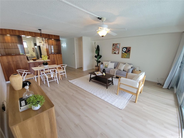 1615 Wilder Ave Unit 604, Honolulu, HI 96822 - living area featuring a textured ceiling, light wood finished floors, ceiling fan, and baseboards
