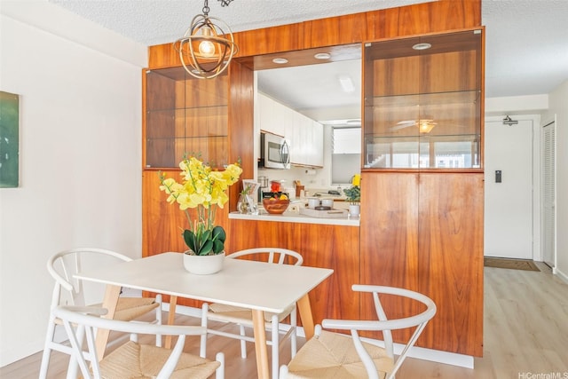 1615 Wilder Ave Unit 604, Honolulu, HI 96822 - dining area with light wood-style flooring and a textured ceiling