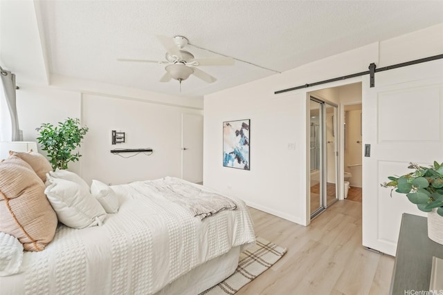 1615 Wilder Ave Unit 604, Honolulu, HI 96822 - bedroom with a barn door, light wood-type flooring, ceiling fan, and baseboards