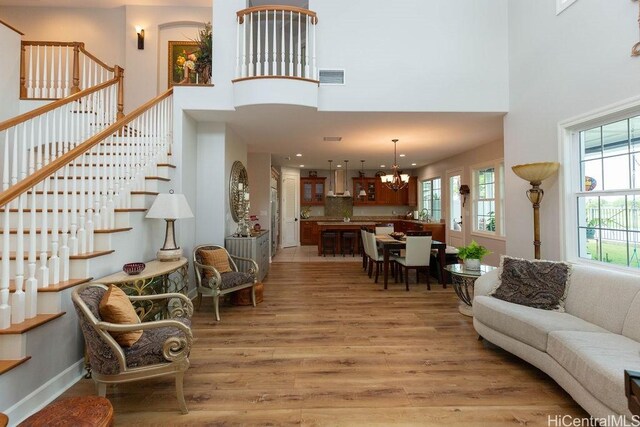 91-1068 Kaikohola St, Ewa Beach, HI 96706 - living area with stairway, light wood finished floors, a high ceiling, a notable chandelier, and visible vents
