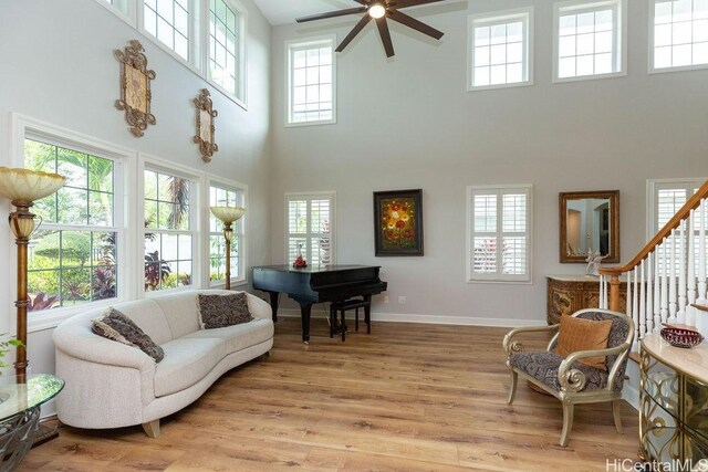 91-1068 Kaikohola St, Ewa Beach, HI 96706 - living room with light wood-style flooring, baseboards, a high ceiling, stairway, and ceiling fan