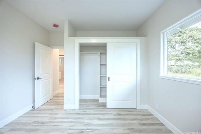 15-1692 7th Ave, Keaau, HI 96749 - unfurnished bedroom featuring a closet, baseboards, light wood-style flooring, and multiple windows