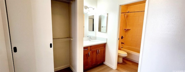 bathroom featuring vanity, wood finished floors, bathing tub / shower combination, and toilet