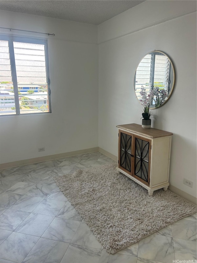 837 Kapahulu Ave Unit 302, Honolulu, HI 96816 - unfurnished room featuring light marble finish floors, plenty of natural light, and a textured ceiling