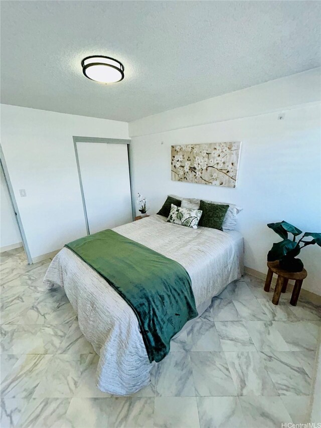 837 Kapahulu Ave Unit 302, Honolulu, HI 96816 - bedroom with light marble finish floors, a textured ceiling, and a closet