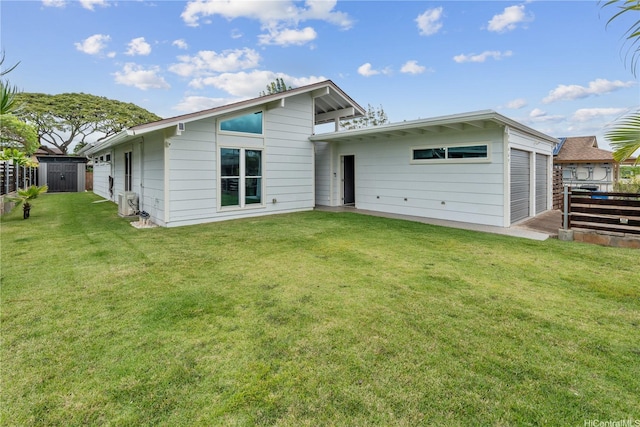 back of property featuring fence, a lawn, an outdoor structure, and a shed