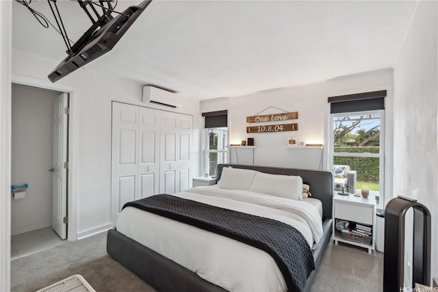 bedroom with an AC wall unit, carpet flooring, and a closet