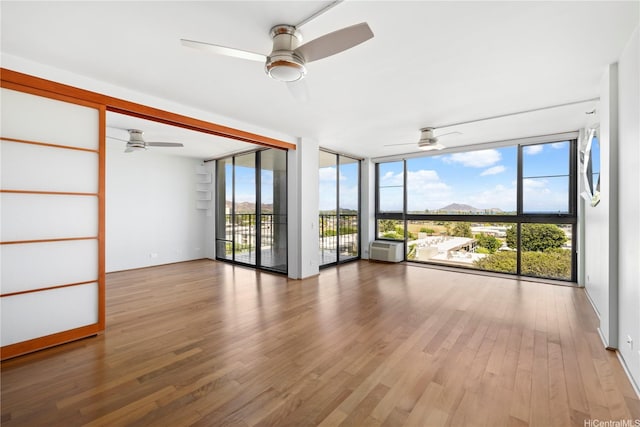 322 Aoloa St Unit 907, Kailua, HI 96734 - unfurnished room with a wall of windows, wood finished floors, a ceiling fan, and a mountain view