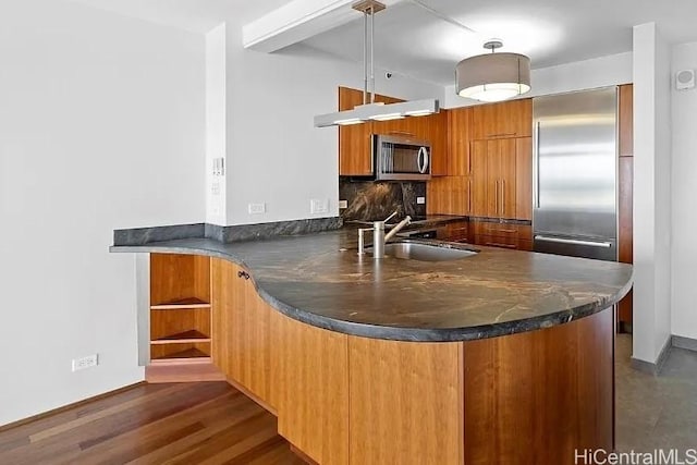 322 Aoloa St Unit 907, Kailua, HI 96734 - kitchen with dark countertops, a sink, a peninsula, brown cabinetry, and appliances with stainless steel finishes