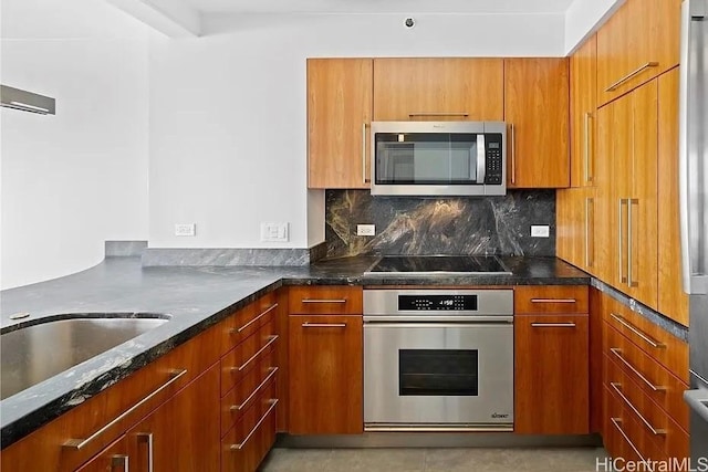 322 Aoloa St Unit 907, Kailua, HI 96734 - kitchen with dark stone countertops, backsplash, a sink, brown cabinetry, and appliances with stainless steel finishes