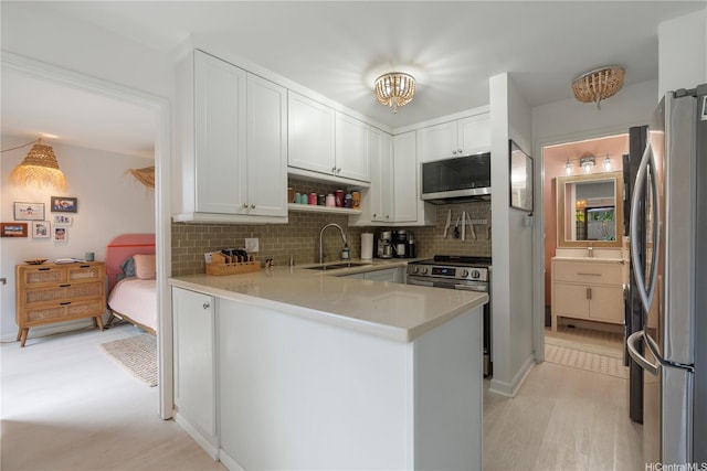 6129 Summer St Unit 6129D, Honolulu, HI 96821 - kitchen with appliances with stainless steel finishes, a peninsula, a sink, tasteful backsplash, and light countertops
