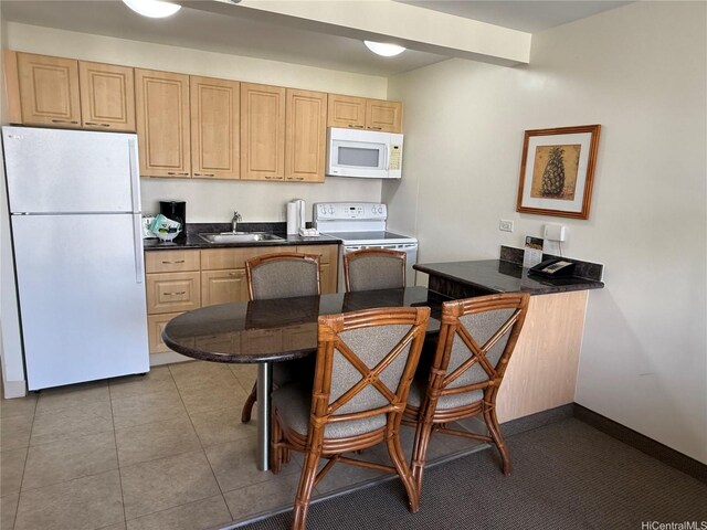 229 Paoakalani Ave Unit 1803, Honolulu, HI 96815 - kitchen featuring tile patterned floors, light brown cabinetry, dark countertops, a sink, and white appliances