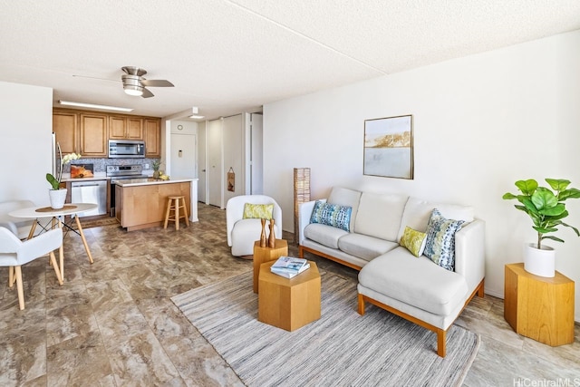 living area featuring ceiling fan and a textured ceiling