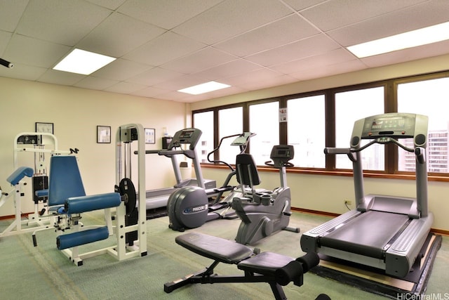 workout area with a drop ceiling and baseboards
