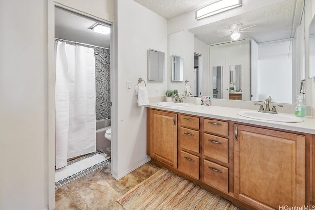 full bathroom with double vanity, curtained shower, toilet, and a sink