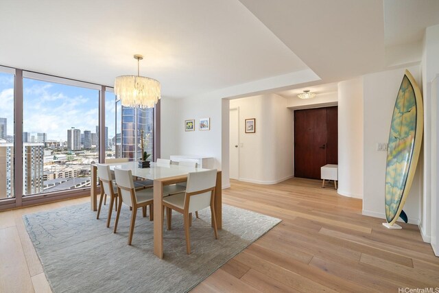 425 S St Unit 2004, Honolulu, HI 96813 - dining room featuring expansive windows, a chandelier, light wood-style flooring, baseboards, and a city view
