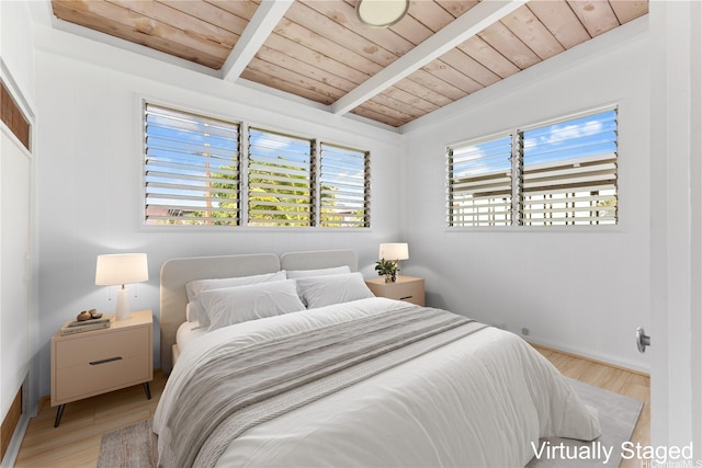 bedroom with light wood-style floors, baseboards, beam ceiling, and wood ceiling