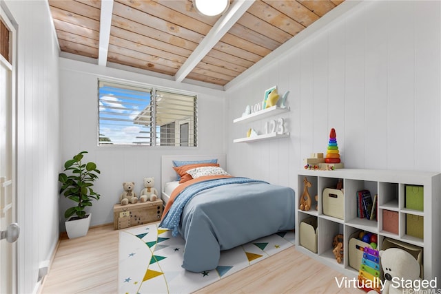 bedroom with beam ceiling, wood finished floors, and wooden ceiling