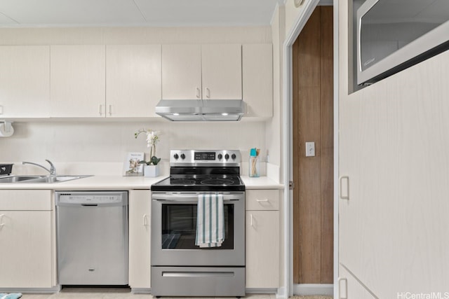 kitchen with range hood, a sink, wood walls, light countertops, and appliances with stainless steel finishes