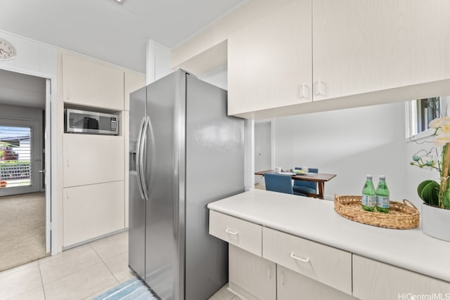 kitchen with light tile patterned floors, stainless steel appliances, and light countertops