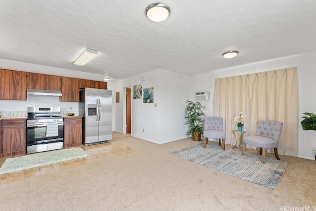 kitchen featuring under cabinet range hood, appliances with stainless steel finishes, light colored carpet, and brown cabinets