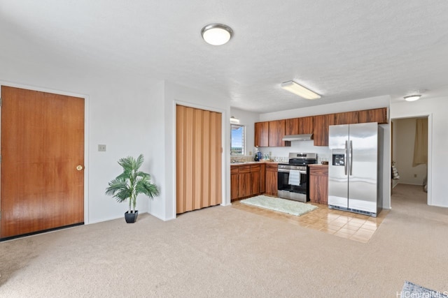 kitchen with stainless steel appliances, light countertops, light carpet, range hood, and brown cabinetry