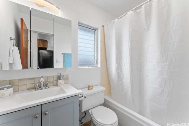 bathroom featuring toilet, shower / bath combo with shower curtain, vanity, and tasteful backsplash