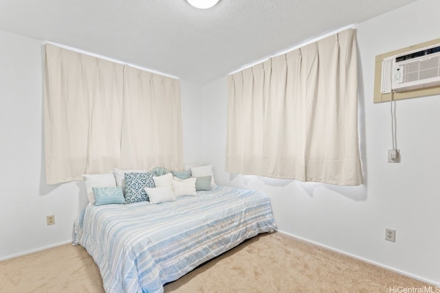 bedroom with baseboards, a wall mounted air conditioner, a textured ceiling, and carpet