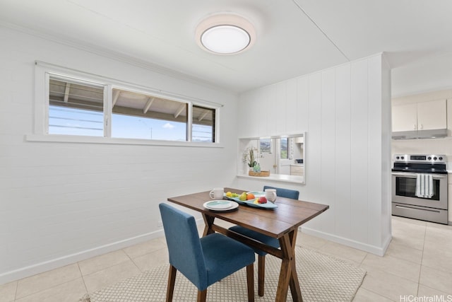 dining space with baseboards and light tile patterned flooring