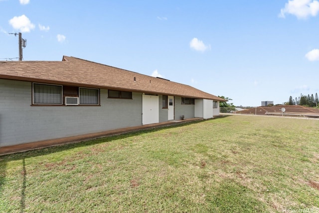 back of property with brick siding, cooling unit, and a lawn