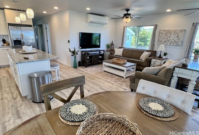 living room with a ceiling fan, recessed lighting, light wood-style floors, and a wall unit AC