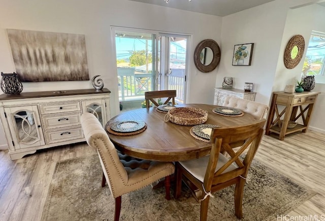 dining room with light wood-style floors, plenty of natural light, and baseboards